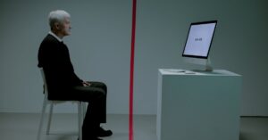 Senior man contemplates ageism with 'too old' displayed on computer screen.